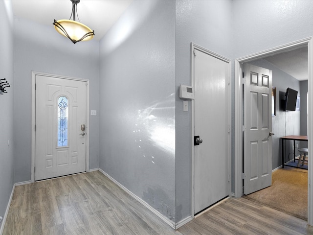 foyer entrance with baseboards and wood finished floors