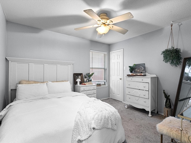 bedroom featuring a closet, a ceiling fan, light carpet, a textured ceiling, and baseboards