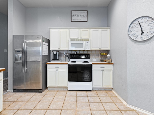 kitchen featuring white microwave, backsplash, stainless steel refrigerator with ice dispenser, and electric stove