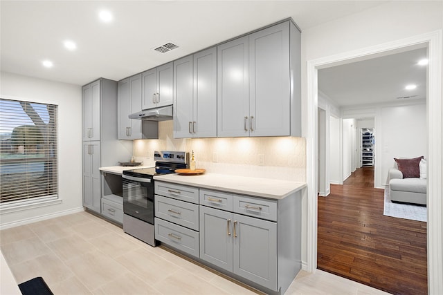 kitchen with visible vents, gray cabinets, stainless steel range with electric cooktop, and under cabinet range hood