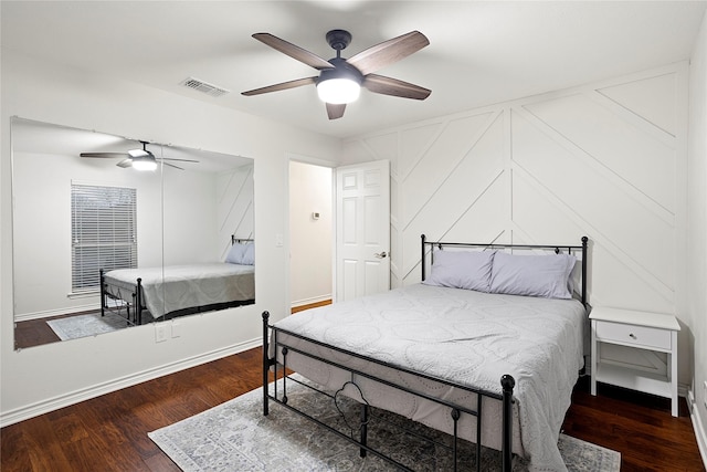 bedroom with ceiling fan, visible vents, baseboards, and wood finished floors