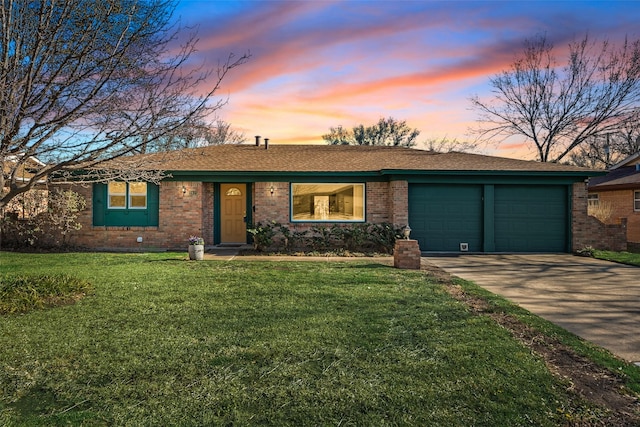 ranch-style house with a yard, brick siding, driveway, and an attached garage