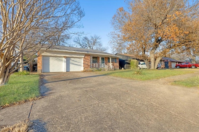 single story home with driveway, a garage, a front lawn, and brick siding