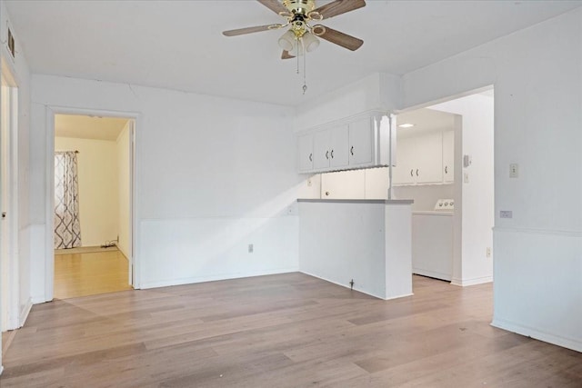 interior space featuring washer / dryer, light wood-type flooring, baseboards, and a ceiling fan