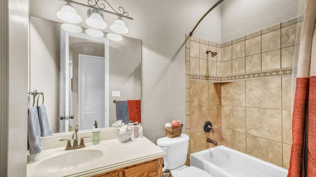 full bath featuring shower / bath combination, vanity, toilet, and a textured wall