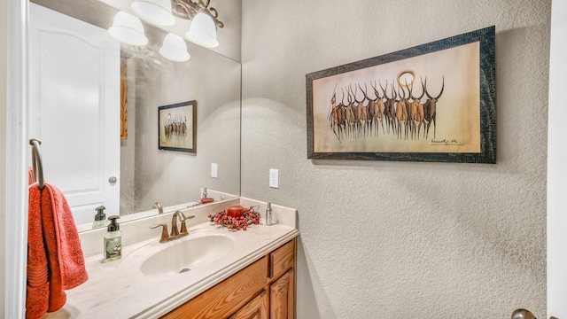 bathroom with a textured wall and vanity