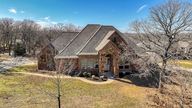 view of front of house with stone siding and a front lawn