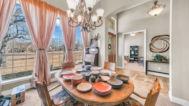 dining room with arched walkways, a high ceiling, baseboards, and an inviting chandelier