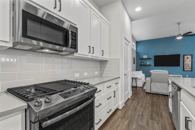 kitchen featuring dark wood-style floors, stainless steel appliances, light countertops, and open floor plan