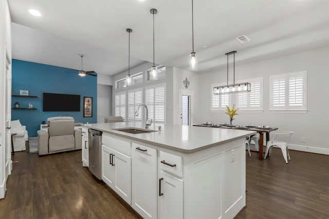 kitchen featuring dark wood-style floors, open floor plan, a sink, a healthy amount of sunlight, and stainless steel dishwasher