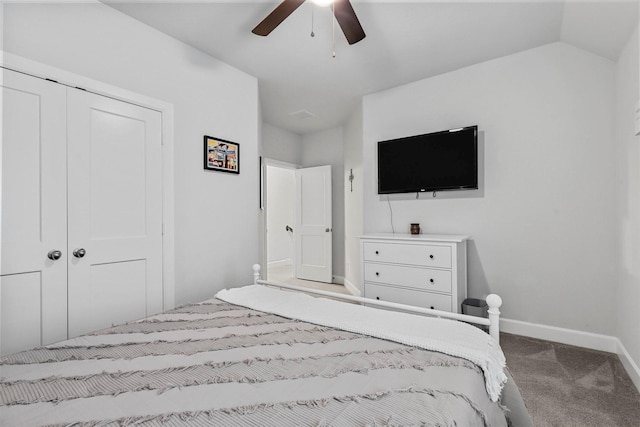 carpeted bedroom with vaulted ceiling, a closet, a ceiling fan, and baseboards