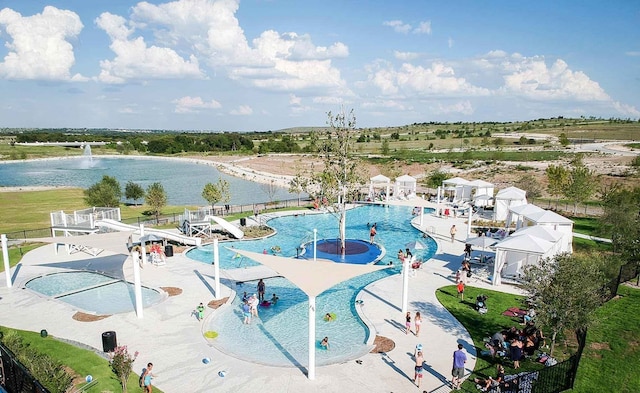 pool with a patio, a water slide, a water view, and a water play area