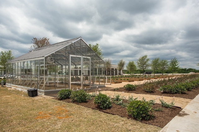 view of home's community featuring a garden, a greenhouse, and an outbuilding