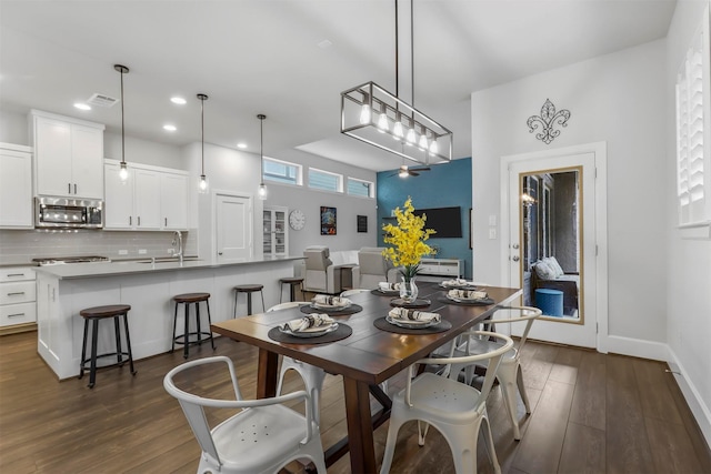 dining room with baseboards, dark wood finished floors, visible vents, and recessed lighting