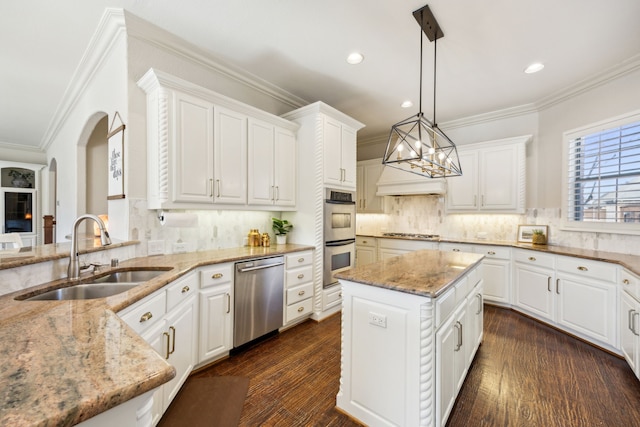 kitchen featuring appliances with stainless steel finishes, dark wood-type flooring, crown molding, white cabinetry, and a sink