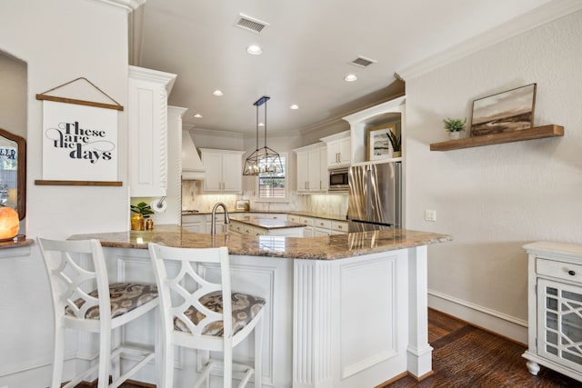 kitchen featuring light stone countertops, visible vents, appliances with stainless steel finishes, and crown molding