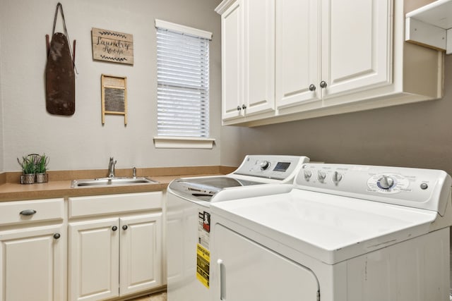 laundry room featuring washing machine and dryer, a sink, and cabinet space