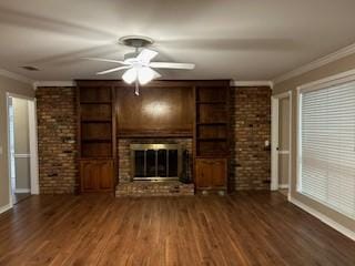 unfurnished living room featuring built in shelves, crown molding, and wood finished floors