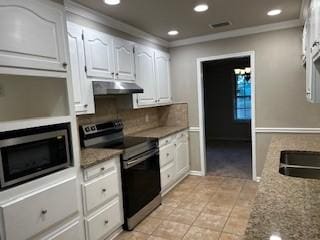 kitchen with under cabinet range hood, range with electric stovetop, backsplash, stainless steel microwave, and crown molding