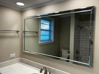 full bath featuring ornamental molding, vanity, toilet, and walk in shower