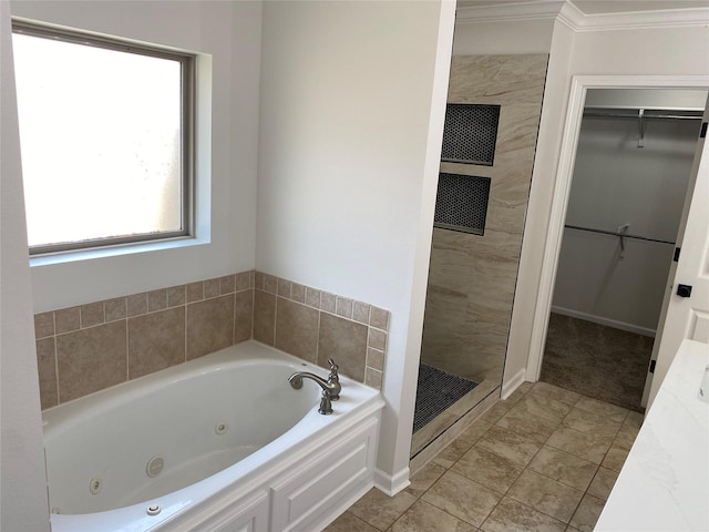 bathroom with a spacious closet, ornamental molding, a stall shower, tile patterned flooring, and a tub with jets