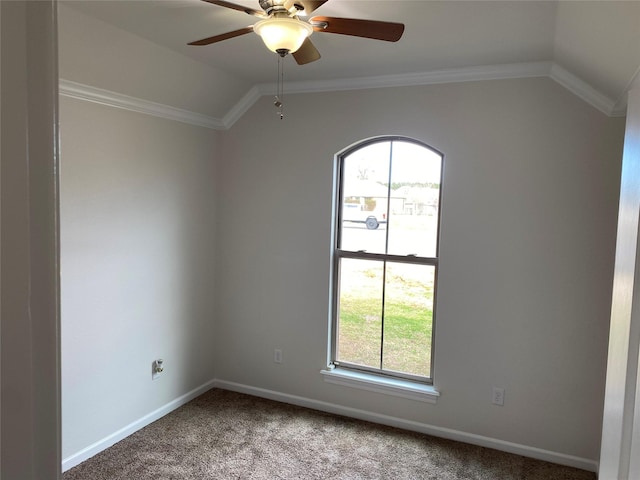 carpeted spare room featuring vaulted ceiling, ornamental molding, a ceiling fan, and baseboards