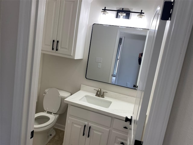 half bathroom with vanity, toilet, and tile patterned floors