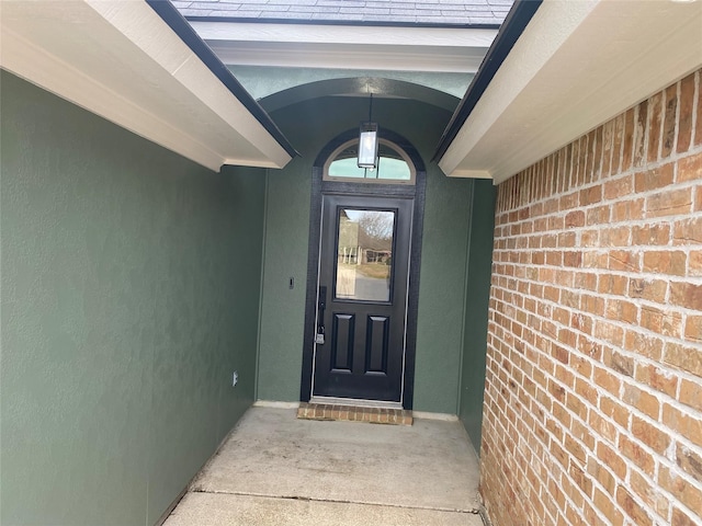 doorway to property with brick siding