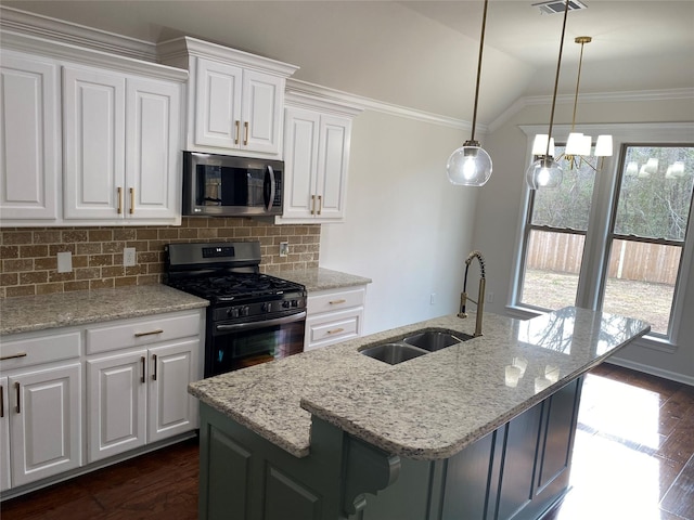 kitchen with lofted ceiling, stainless steel microwave, a sink, ornamental molding, and gas range oven