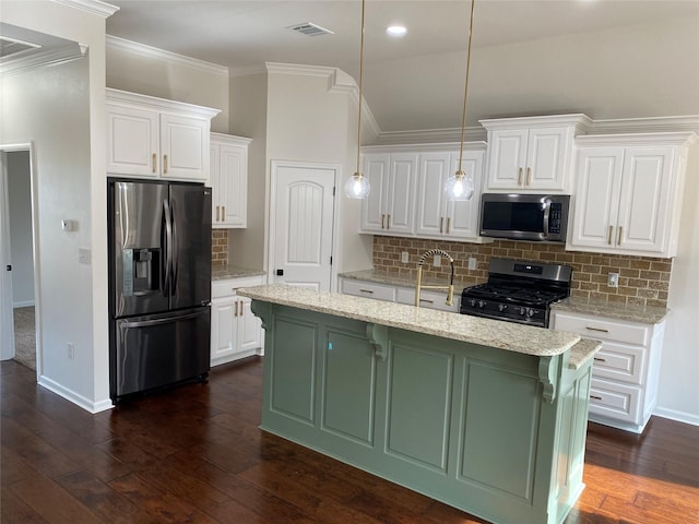 kitchen featuring stainless steel appliances, visible vents, dark wood-type flooring, white cabinetry, and an island with sink