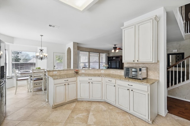 kitchen featuring tasteful backsplash, a wealth of natural light, visible vents, and a peninsula