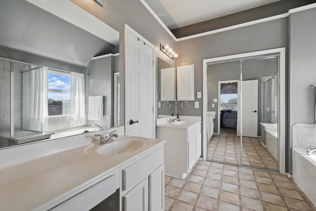 bathroom with a garden tub, two vanities, and a sink