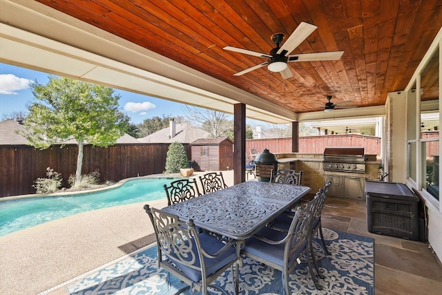 view of patio / terrace with a storage shed, area for grilling, a fenced backyard, a grill, and an outdoor structure