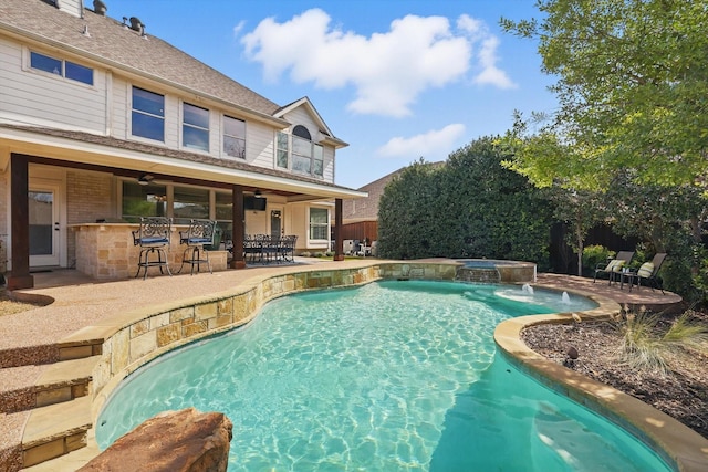 view of swimming pool featuring a ceiling fan, a pool with connected hot tub, a patio area, and outdoor dry bar