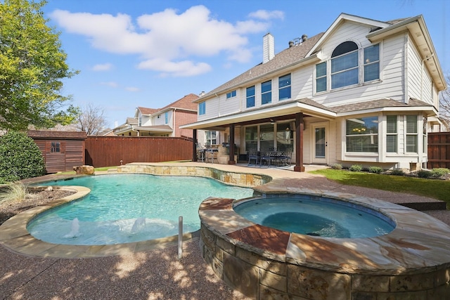 view of swimming pool with an outbuilding, a patio, a fenced backyard, a storage unit, and outdoor dining space