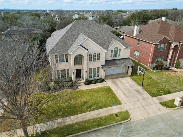 view of front facade featuring a garage, concrete driveway, roof with shingles, and a front lawn