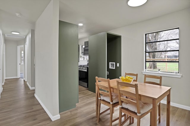 dining area featuring light wood-type flooring and baseboards