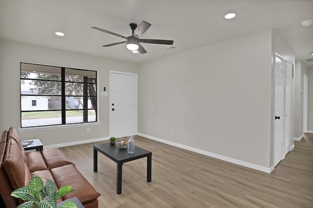 living area with light wood finished floors, recessed lighting, visible vents, and baseboards