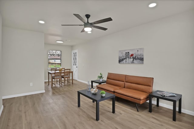 living area with baseboards, recessed lighting, a ceiling fan, and light wood-style floors