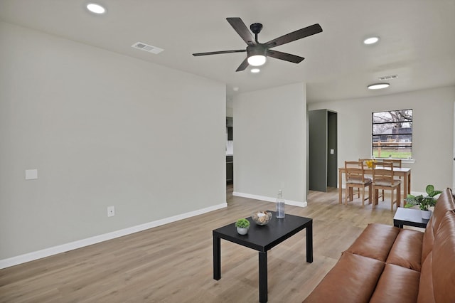 living area featuring light wood-type flooring, baseboards, visible vents, and recessed lighting