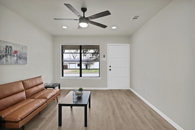 living area with light wood-style flooring, recessed lighting, visible vents, and baseboards