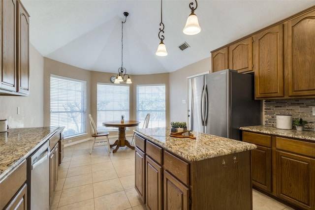 kitchen with light tile patterned flooring, visible vents, appliances with stainless steel finishes, a center island, and tasteful backsplash