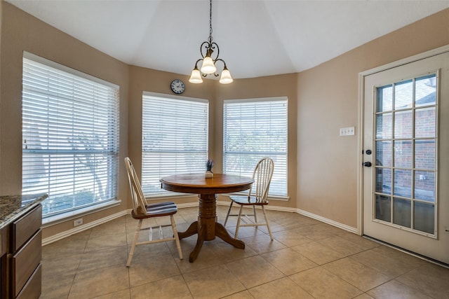 dining area with lofted ceiling, light tile patterned floors, plenty of natural light, and a notable chandelier