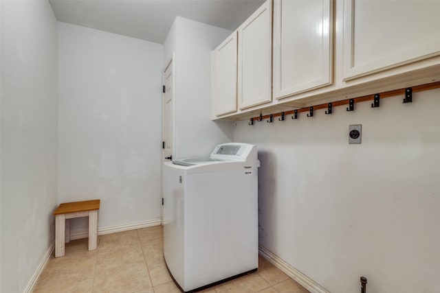 clothes washing area with washer / dryer, light tile patterned floors, baseboards, and cabinet space