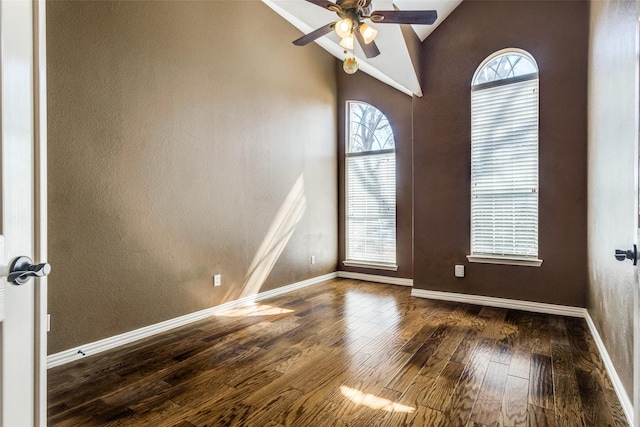 spare room featuring a ceiling fan, high vaulted ceiling, baseboards, and wood finished floors