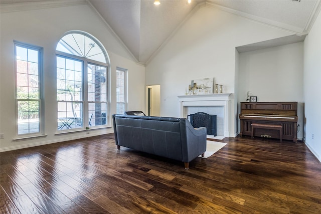 living room with high vaulted ceiling, baseboards, dark wood-style floors, a tiled fireplace, and crown molding