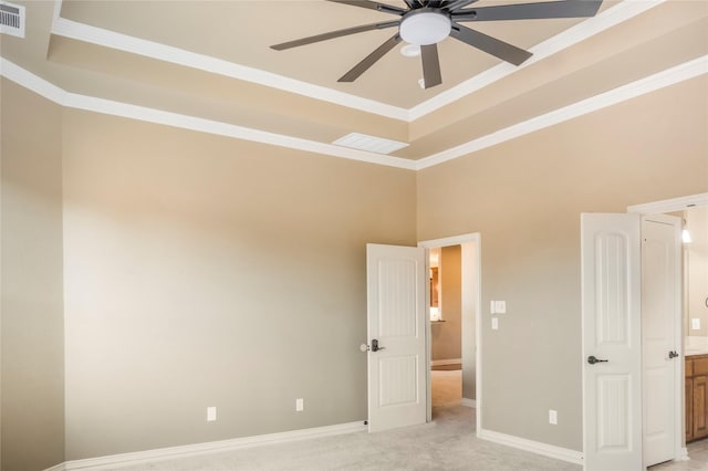 unfurnished bedroom featuring baseboards, visible vents, a raised ceiling, and light colored carpet