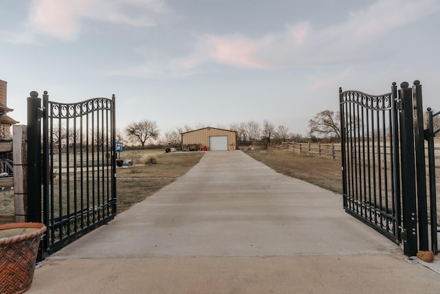 view of gate with an outbuilding and fence