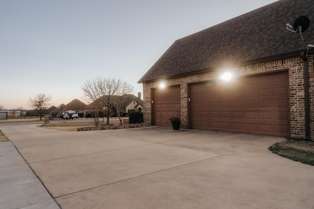 view of side of home featuring brick siding and roof with shingles