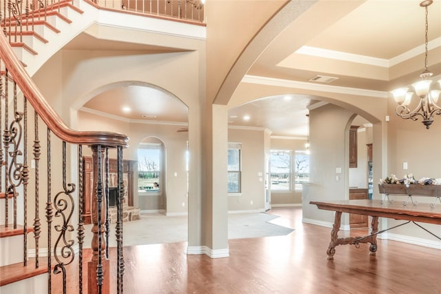 entryway featuring an inviting chandelier, plenty of natural light, baseboards, and wood finished floors